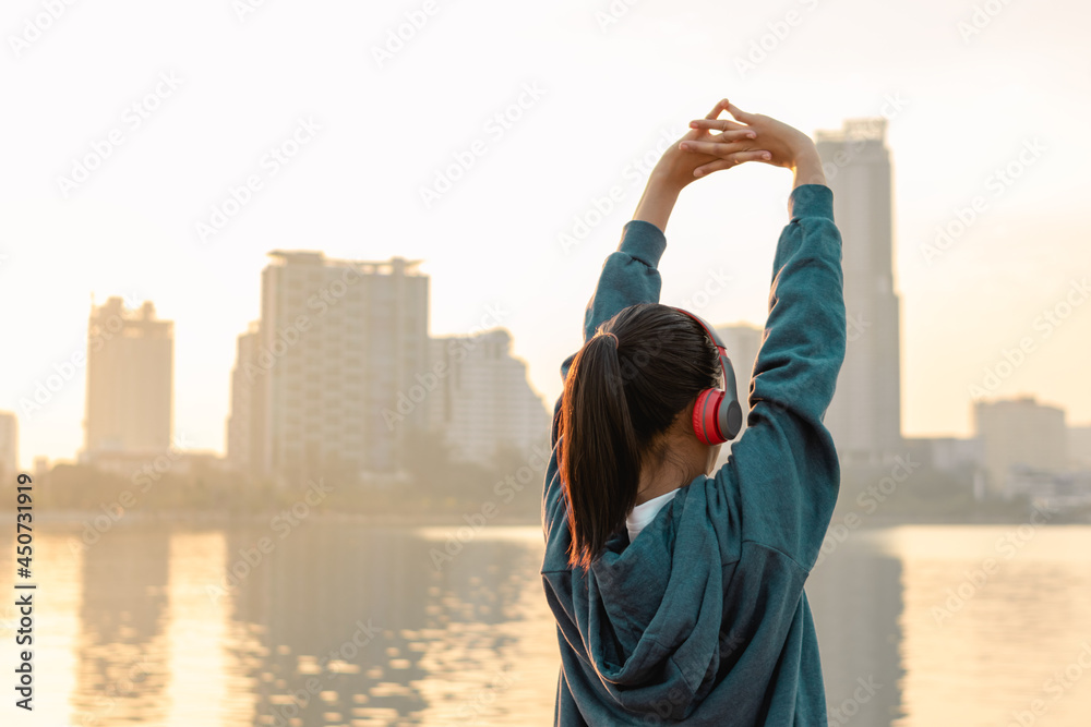 Woman is stretching her arms before workout outdoors in the city. Healthy young woman warming up outdoors in the morning. Woman is stretching her arms before workout outdoors in the city. Healthy young woman warming up outdoors in the morning.