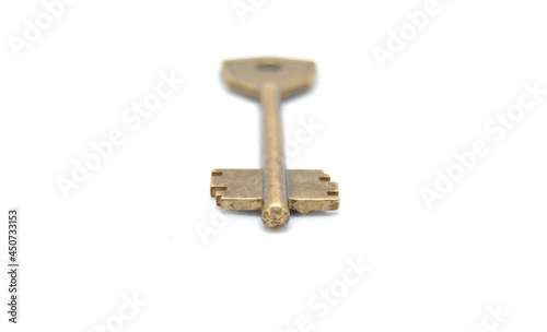 Vintage key on white background close-up. Texture, background, old, macro, wallpaper, metal, brass