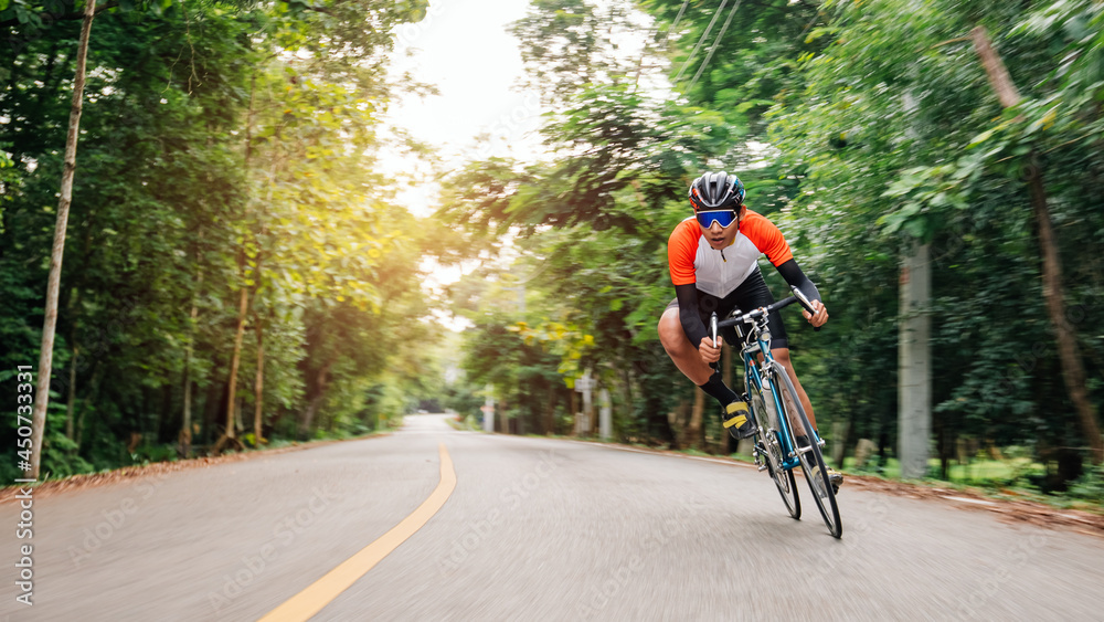 A man ride on bike on the road. Man riding vintage sports bike for evening exercise. A man ride bicycle to breathe in the fresh air in midst of nature, meadow, forest, with evening sun shining through