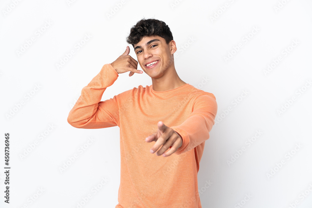 Young man over isolated white background making phone gesture and pointing front Young man over isolated white background making phone gesture and pointing front
