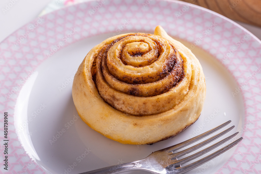 Sweet homemade cinnamon roll, bun with cinnamon powder Sweet homemade cinnamon roll, bun with cinnamon powder