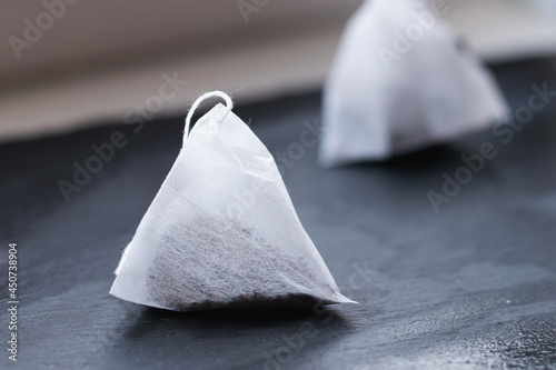triangular bags of black tea on a black background. Black Tea in pyramids.
