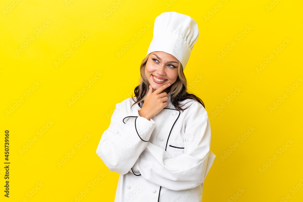 Young Russian chef girl isolated on yellow background looking to the side Young Russian chef girl isolated on yellow background looking to the side