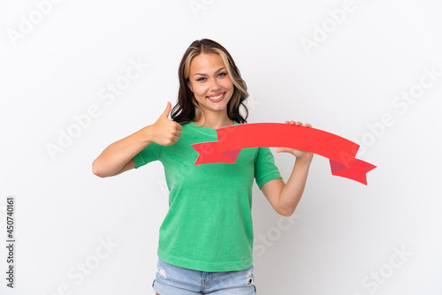 Teenager Russian girl isolated on blue background holding an empty placard with thumb up
