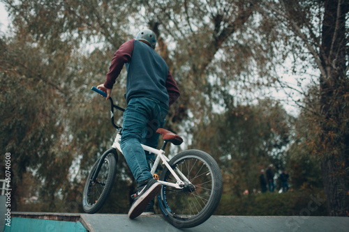 Professional young sportsman cyclist with bmx bike at skatepark