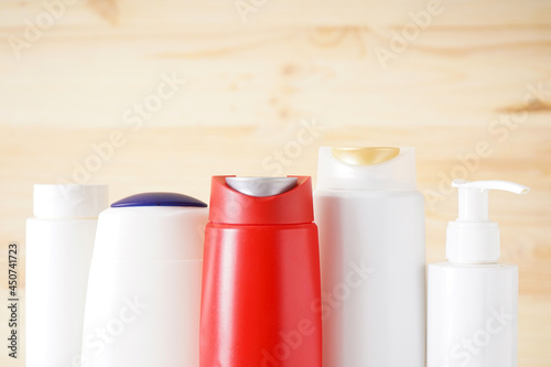 Different cosmetic bottles on wooden background, place for text. Close-up.