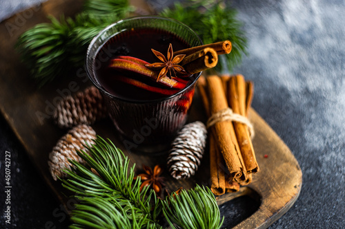 Glass of mulled wine with spices on concrete background