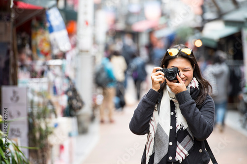 woman taking a picture with digital mirrorless camera in Tokyo photo