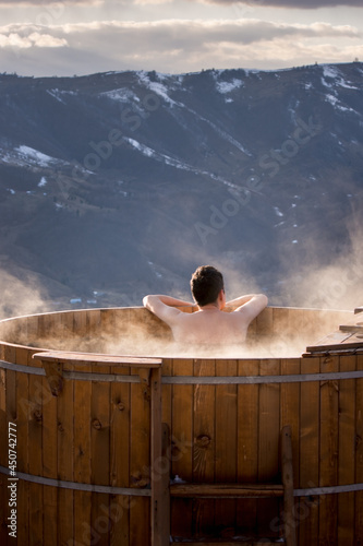 Adult man relaxes in barrel with hot water, in winter, Transylva photo