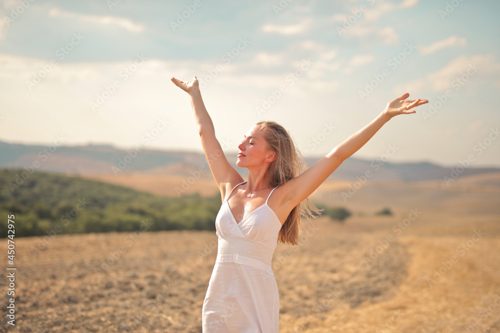 young woman breathes air with open arms in the countryside young woman breathes air with open arms in the countryside