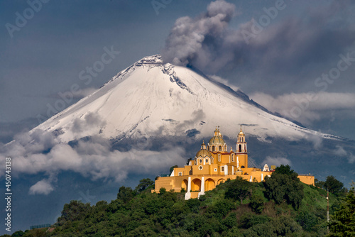 Morning view of church and a volcano behind with snow photo