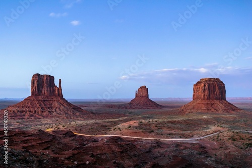 Car light trails along a road after sunset in Monument Valley.