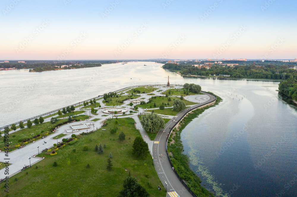 Tourist spot of Strelka Park on the Yaroslavl embankment and a view from the height of the Assumption Cathedral in Yaroslavl against the background of a summer sunset.