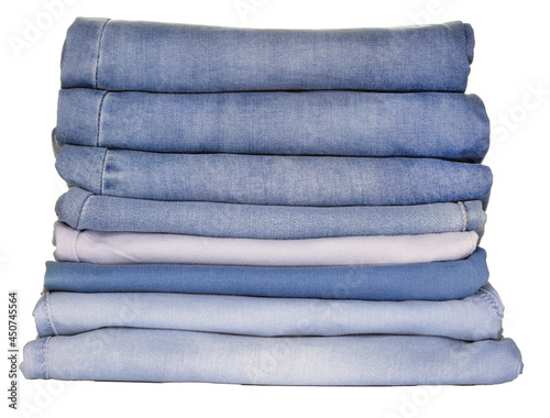 Jeans of various fabrics lie in a pile on a white background, isolate