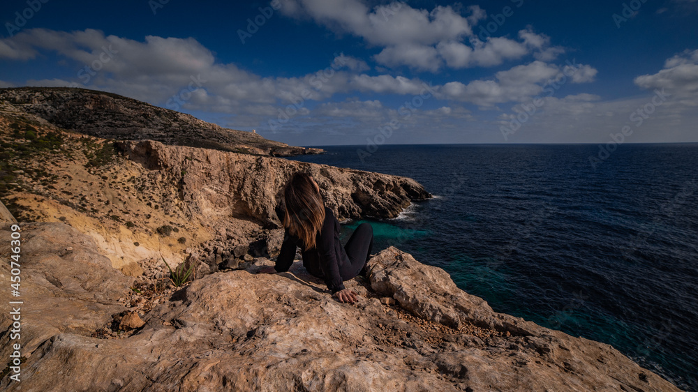 Girl admires view from cliffs in Malta