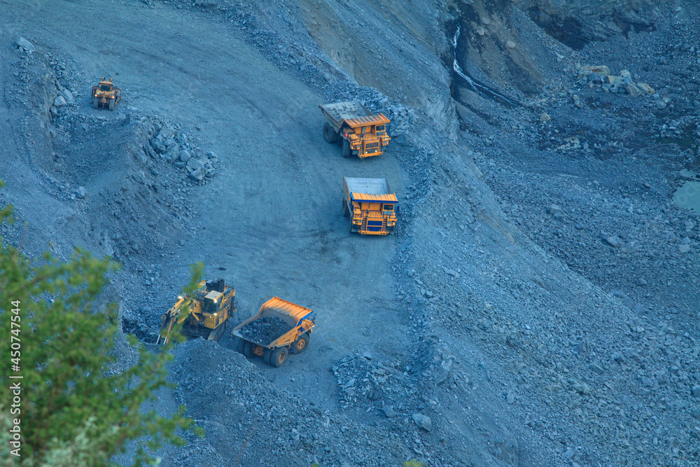 The process of mining iron ore in a quarry with large excavators and trucks. Heavy iron ore mining industry at night The process of mining iron ore in a quarry with large excavators and trucks. Heavy iron ore mining industry at night
