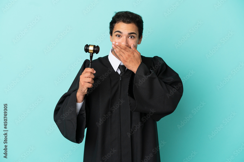 Naklejka premium Judge over isolated blue background happy and smiling covering mouth with hand