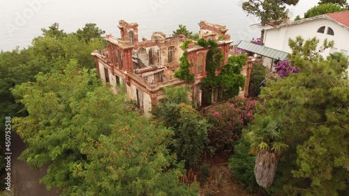 Tracking shot over a destroyed red brick villa on Prinkipo Island, Büyükada in the Sea of Marmara near Istanbul, Turkey. The communist Leon Trotsky lived here photo