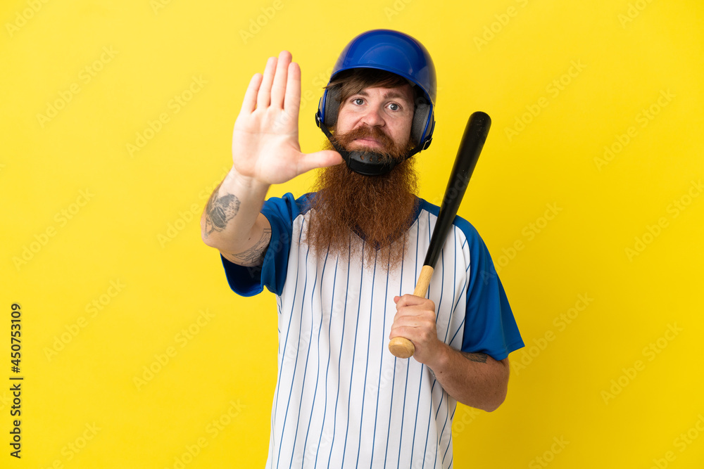 Redhead baseball player man with helmet and bat isolated on yellow background making stop gesture Redhead baseball player man with helmet and bat isolated on yellow background making stop gesture