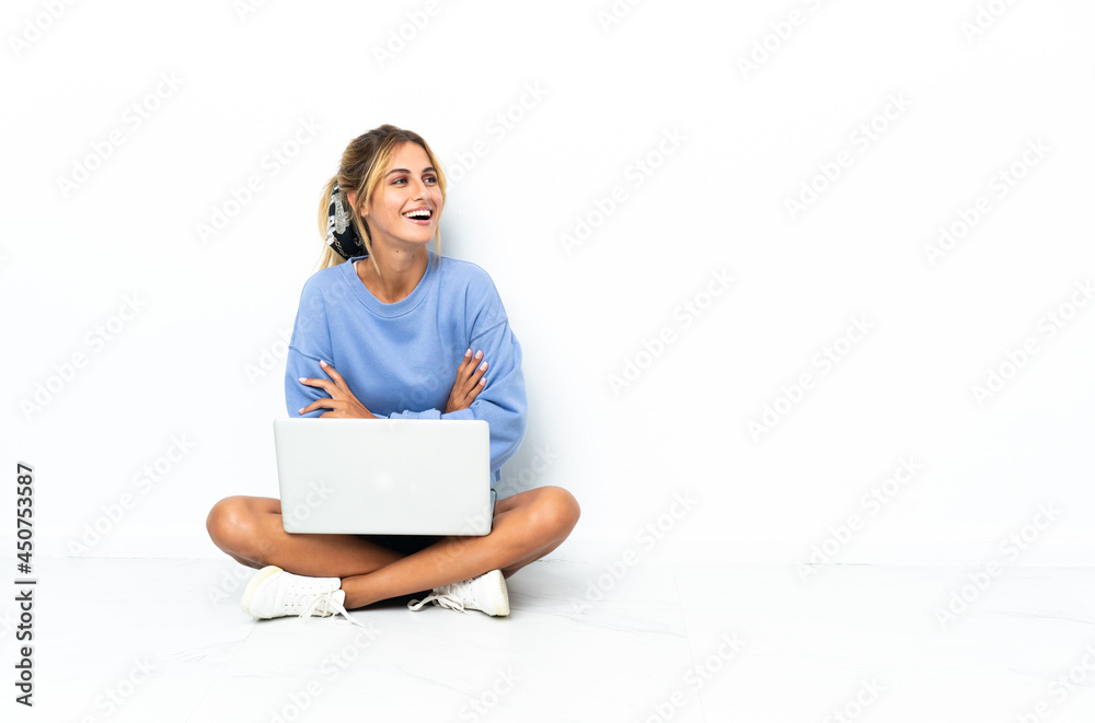 Young blonde Uruguayan girl with the laptop isolated on white background happy and smiling Young blonde Uruguayan girl with the laptop isolated on white background happy and smiling
