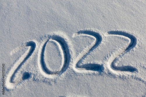 the inscription about the new year 2022 on the snow in winter