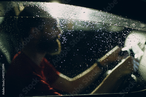Man driver sits at steering wheel of car at night.