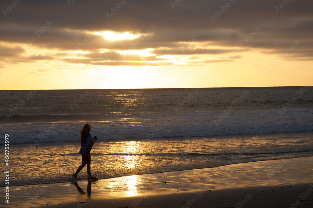 Girl Walking on beach at Sunset