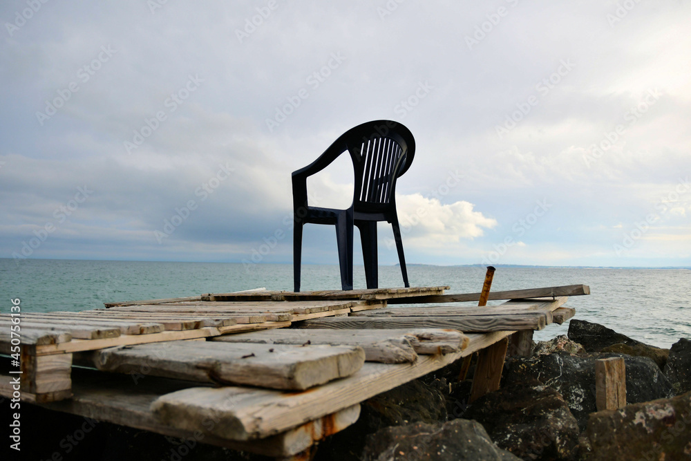 Summer sea blue sky horizon old black chair wooden pallet macro closeup background 