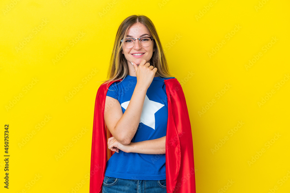 Super Hero Romanian woman isolated on yellow background with glasses and smiling Super Hero Romanian woman isolated on yellow background with glasses and smiling