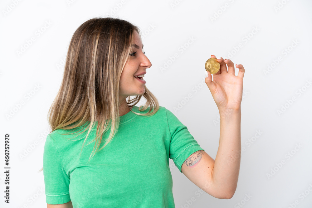 Young Romanian woman holding a Bitcoin isolated on white background with happy expression