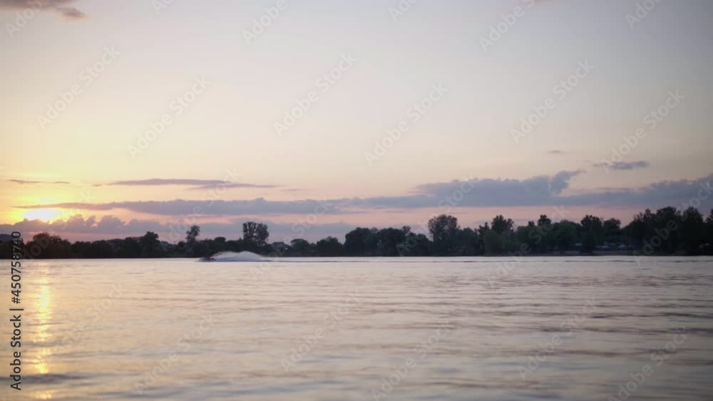 Man Riding Jetski at Sunset On Lake Silhouette Rider Jet Ski Driving Water bike Extreme Water Sport Man Riding Jetski at Sunset On Lake Silhouette Rider Jet Ski Driving Water bike Extreme Water Sport