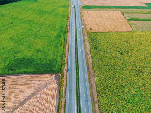 Aerial view of the road between agricultural fields in Europe. Beautiful landscape. Captured from above with a drone