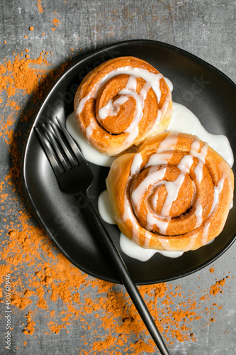 Homemade cinnamon rolls with coffee icing on a dark background
