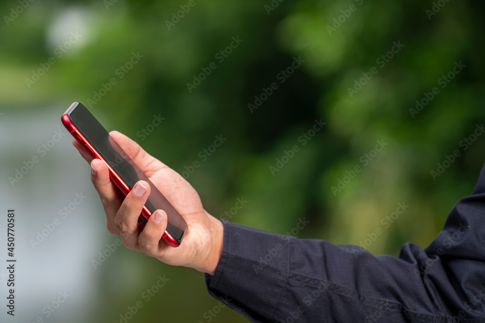 Man Hand hands holding smart phone blur nature background, people use smart phone for contact education, online marketing, business, online technology.