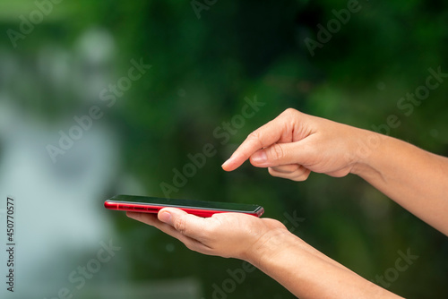 Man Hand hands holding smart phone blur nature background, people use smart phone for contact education, online marketing, business, online technology. © MERCURY studio