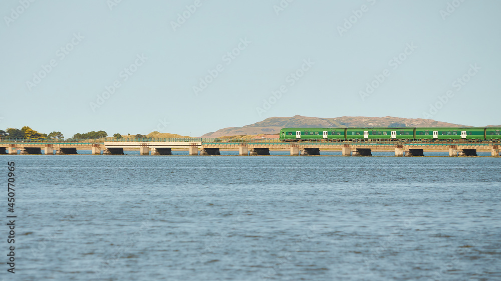 Fototapeta premium View from sea on the Malahide Bridge, railroad bridge with Dart train passing.