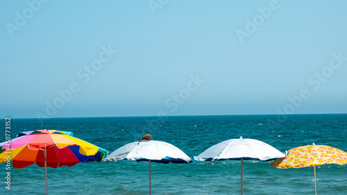 4 Colorful Umbrella on the Beach in a Hot Summer Day