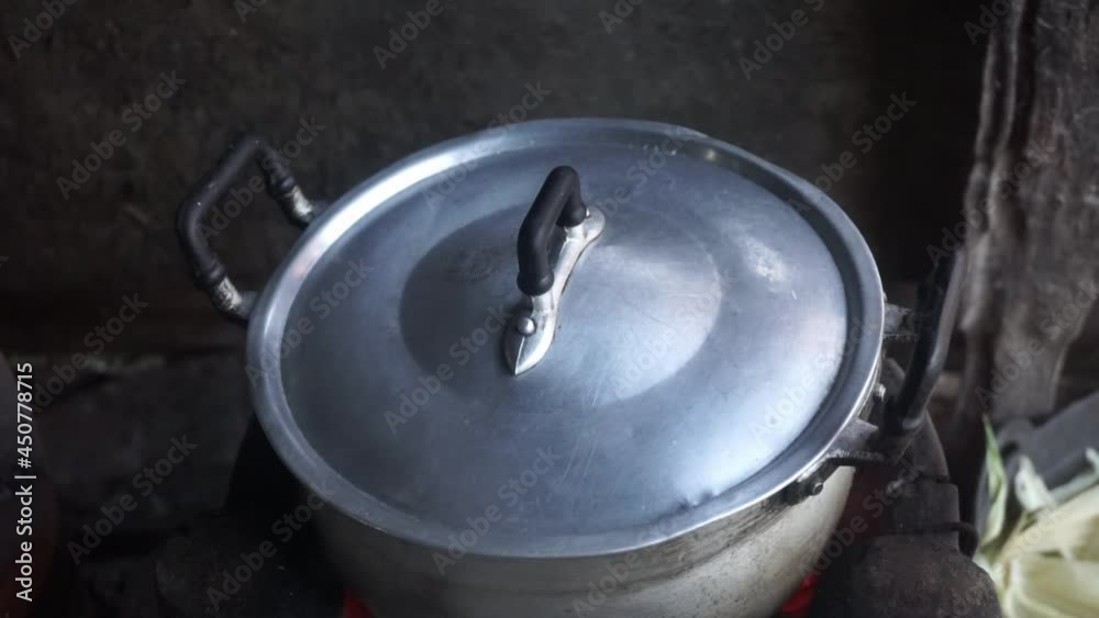 Close-up of iron pot with lid standing on the wood in fire Cooking food at fire in wild.
Close-up of iron pot with lid standing on the wood in fire Cooking food at fire in wild.