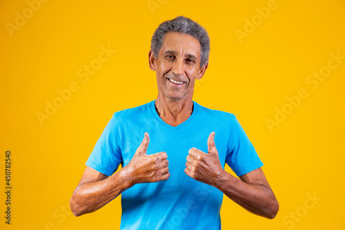 elderly man with thumb up giving thumbs up. photo