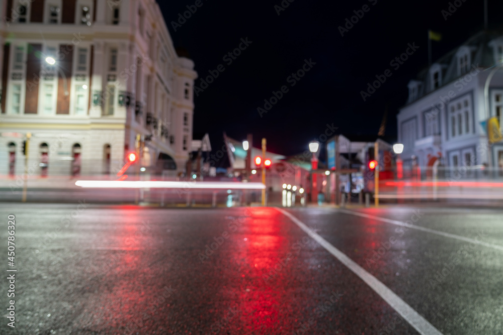 Passing vehicle and light streams blurs for urban nighttime background at Jervois Quay crossing