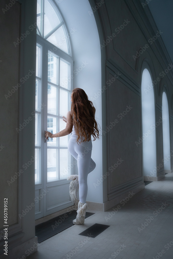 Full size body length of lovely charming beautiful nice stylish girl doing everyday warming up exercises in modern light white interior next to big window Full size body length of lovely charming beautiful nice stylish girl doing everyday warming up exercises in modern light white interior next to big window