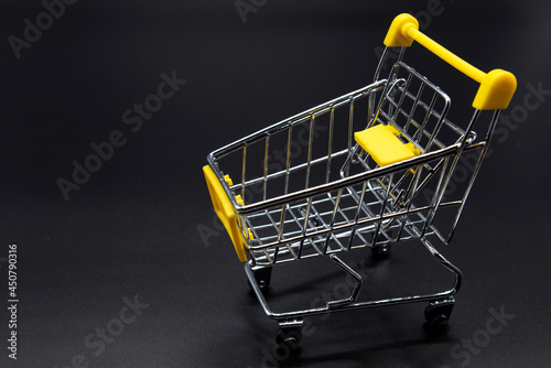 Yellow mini shopping cart or trolley on black