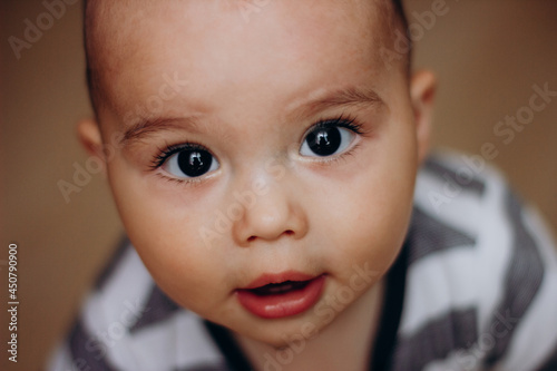 Cutte little baby boy with big dark eyes and long lashes. Portrait of sweet infant