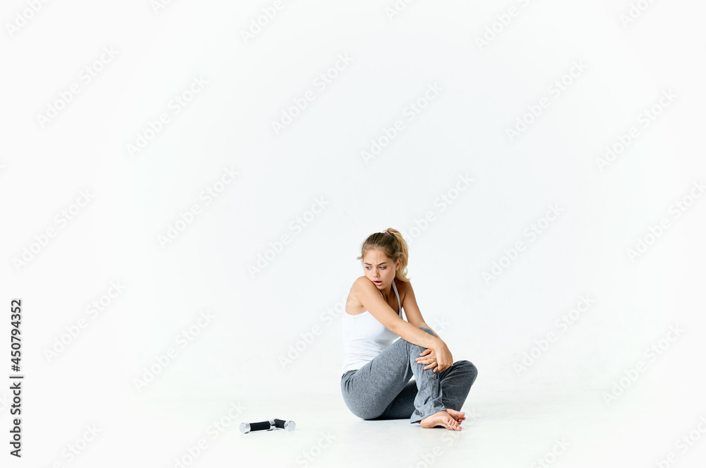 woman with dumbbells in her hands sitting on the floor exercise gym woman with dumbbells in her hands sitting on the floor exercise gym