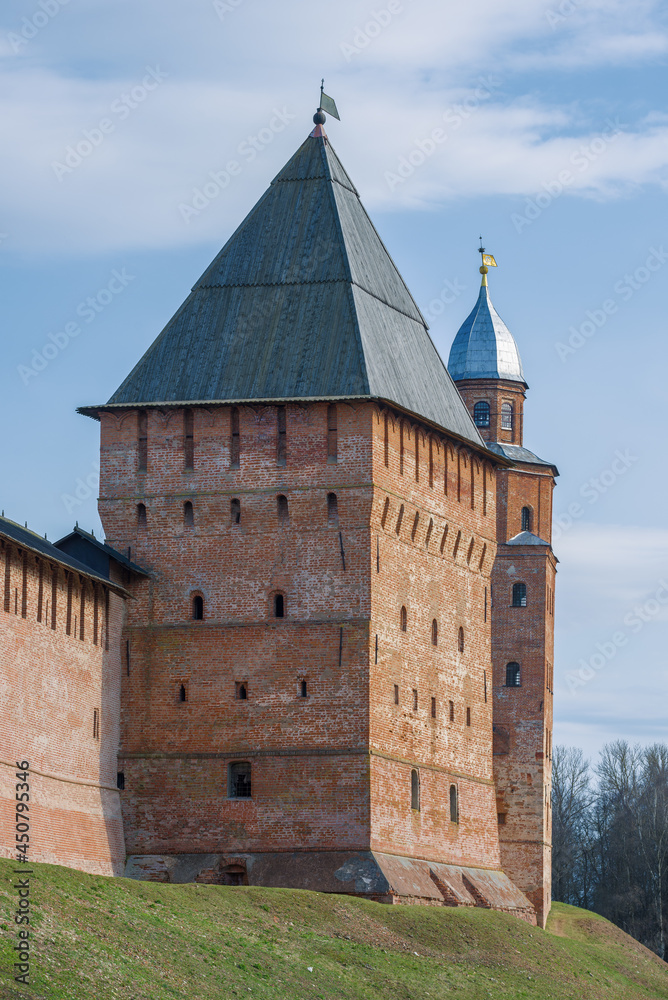 Pokrovskaya tower against the background of the Kokui tower on a April sunny day. Detinets of Veliky Novgorod, Russia