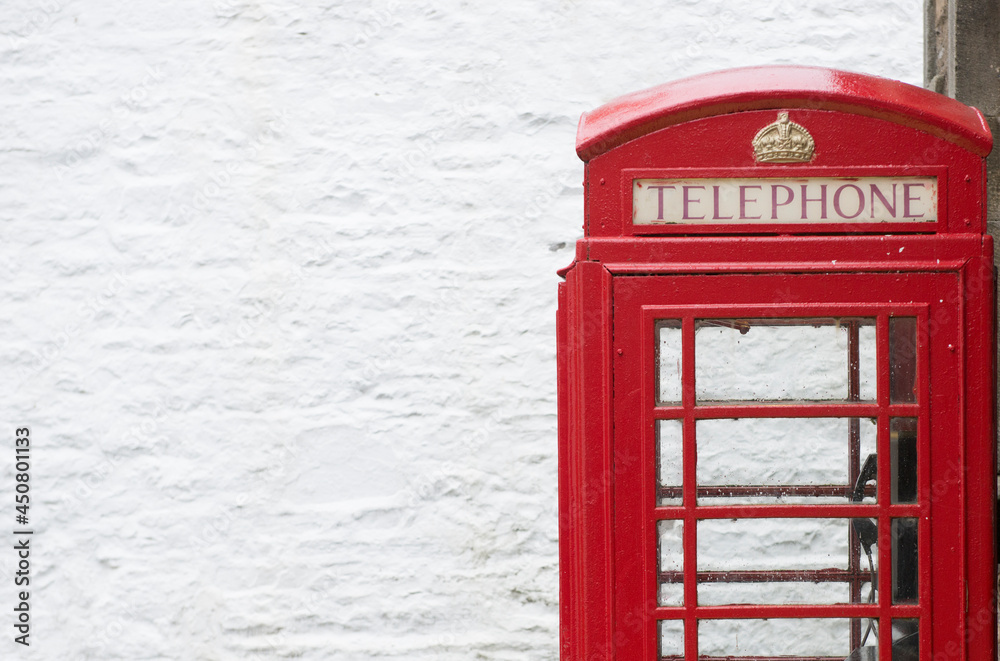 Obraz premium red british telephone box against a white wall