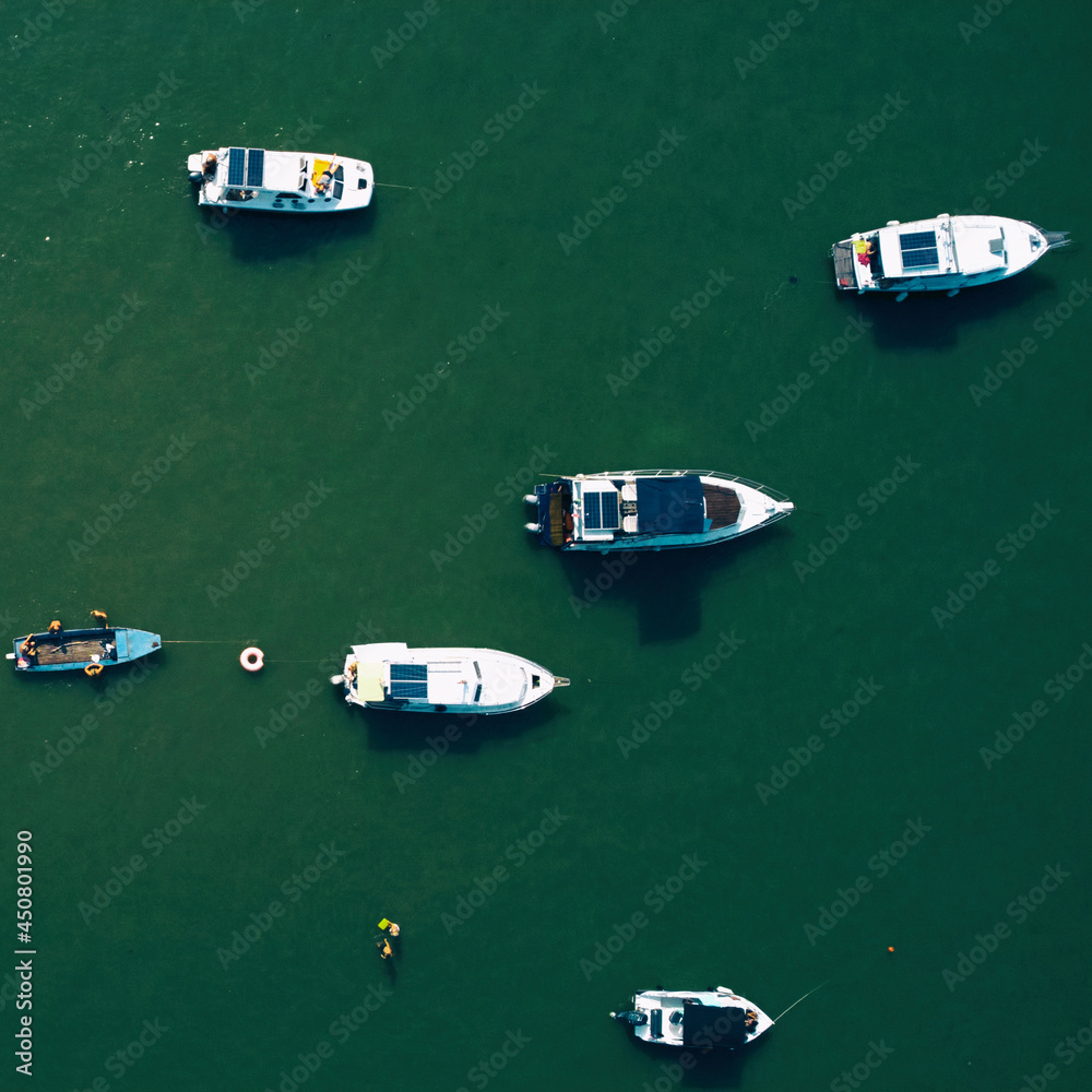 Many fishing and small boats parked on a river. Drone view.