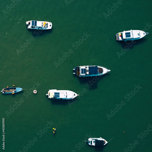 Many fishing and small boats parked on a river. Drone view. © astrosystem