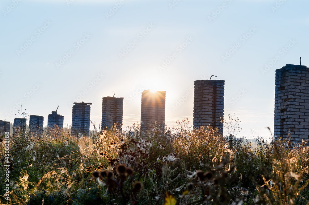 brick pillars in a field from a destroyed building at sunrise brick pillars in a field from a destroyed building at sunrise