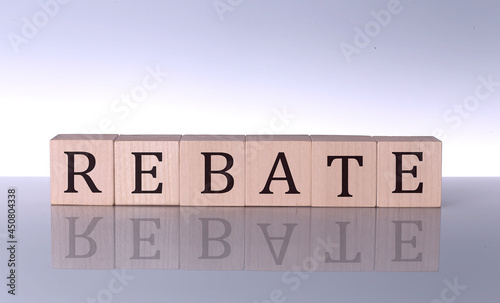REBATE concept, wooden word block on the grey background